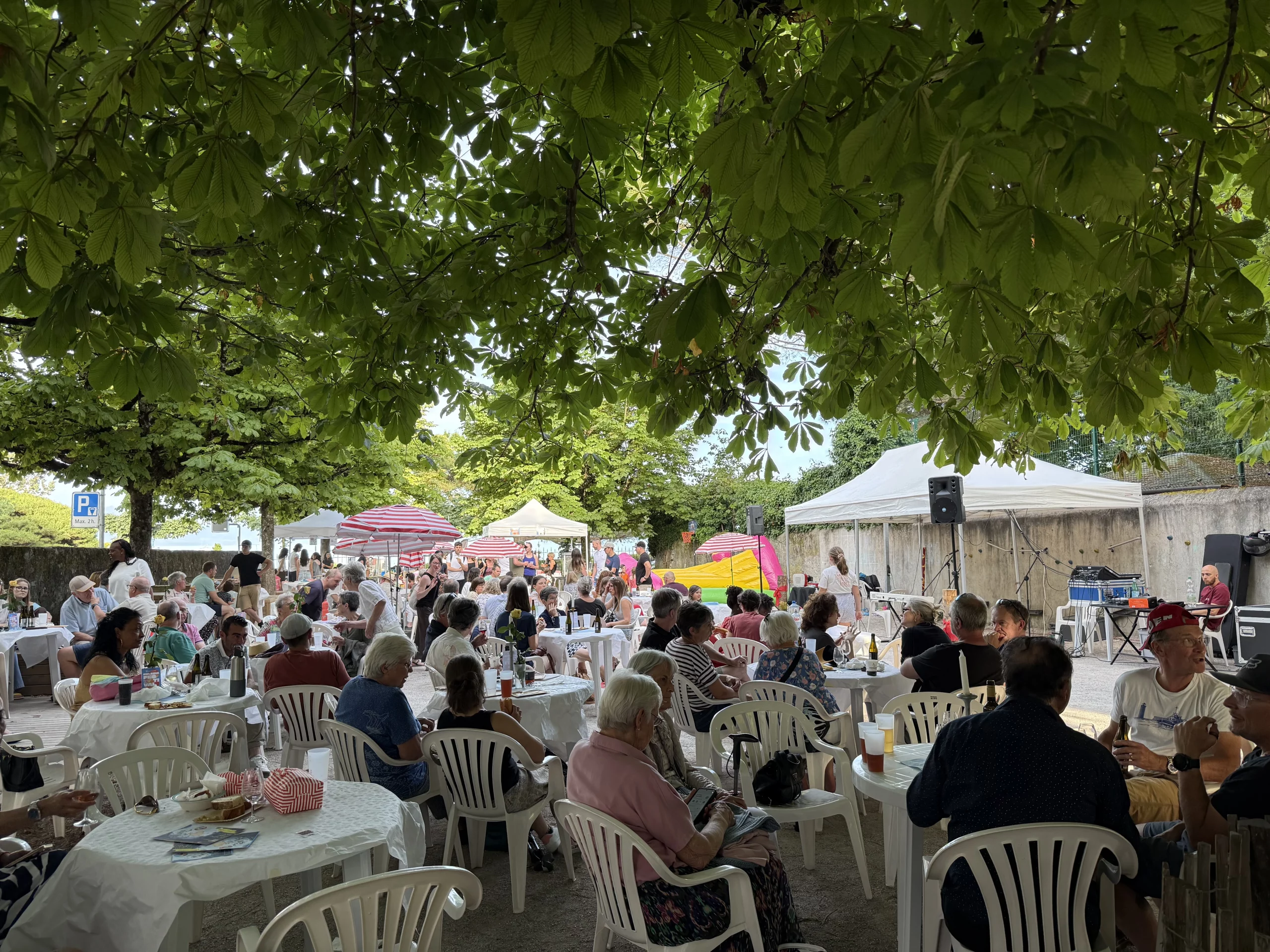 Participants réunis lors de l'Eklesia Festival à Morges autour des stands, animations et espaces de restauration sous les arbres.